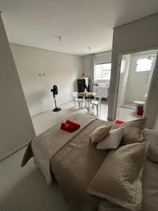 a bedroom with a large bed and a table at 05 Studios centro,proximo a rodoviaria-itapeva sp in Itapeva
