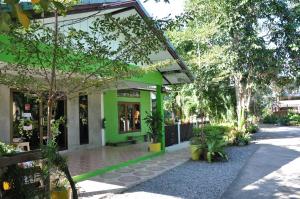 un edificio verde con árboles y plantas delante de él en Feel Good Resort, en Nakhon Ratchasima