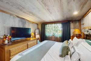a bedroom with a large bed and a flat screen tv at Walk to Trails & Fishing Spots! Lake Ozark Escape in Four Seasons