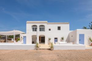 a white house with blue doors and plants at New! Villa Plana Menut in Santa Gertrudis de Fruitera
