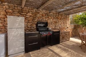 a kitchen with a stove and a refrigerator at New! Villa Plana Menut in Santa Gertrudis de Fruitera