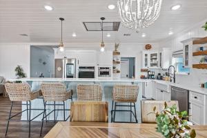 a kitchen with white cabinets and bar stools at Just Beach It! in Port Bolivar