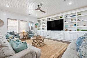 a living room with white cabinets and a flat screen tv at Just Beach It! in Port Bolivar