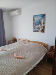 a bedroom with a bed with two slippers on it at Maja Apartman in Igalo