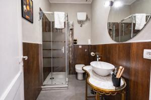 a bathroom with a sink and a toilet and a mirror at Sa Costixedda Rooms in Cagliari