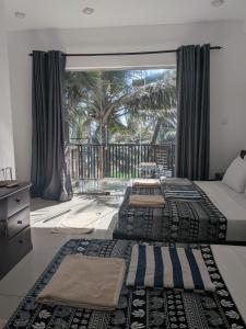 two beds in a bedroom with a large window at Dickwella Beach in Dickwella +106 photos