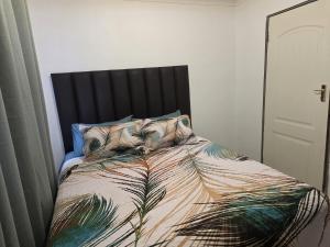 a bedroom with a bed with a comforter with feathers at One Bedroom Apartment B in Kempton Park