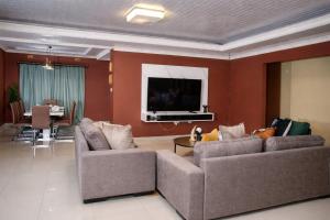 a living room with two couches and a flat screen tv at Maun Fortress in Maun Airport