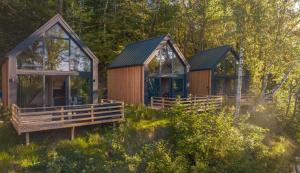 two cottages in the middle of a forest at Leśne Szepty Resort in Zebrzydów