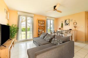 a living room with a couch and a flat screen tv at Bon Repos - 2 chambres in Léguevin