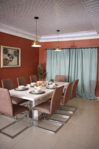 a dining room with a white table and chairs at Maun Fortress in Maun Airport