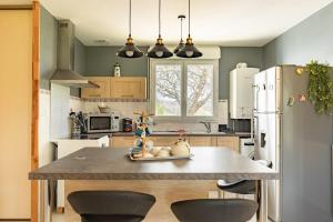 a kitchen with a large kitchen island with two chairs at Bon Repos - 2 chambres in Léguevin