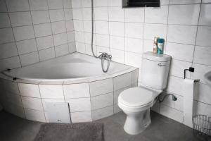 a bathroom with a toilet and a bath tub at Maun Fortress in Maun Airport +99 photos