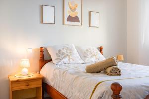 a bedroom with a bed and a nightstand with a lamp at Bon Repos - 2 chambres in Léguevin