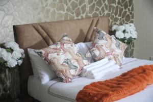 a white bed with pillows on top of it at Maun Fortress in Maun Airport