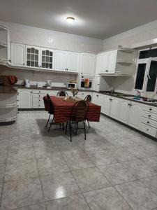 a kitchen with white cabinets and a table and chairs at Descanso imparcial in Prazeres