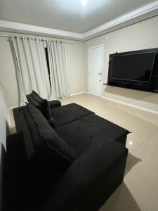 a living room with a couch and a flat screen tv at Aparth ijui hotel in Ijuí +21 photos