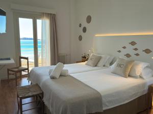 two beds in a bedroom with a view of the ocean at Carabela in Paguera