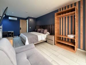 a bedroom with a bed and a chair and a couch at Hotel Plaza Doce in Pereira