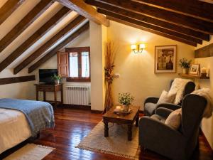 a living room with a bed and a couch and a table at Posada El Hoyal in Pesaguero-La Parte