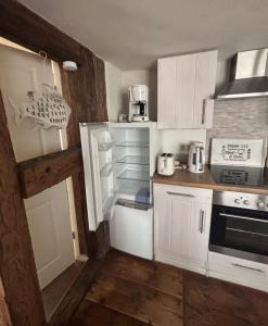 a kitchen with white cabinets and an open refrigerator at Haus Wünsche in Wieck