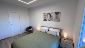 a bedroom with a green bed and two lamps at Casa Amarèa in Fano