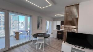 a living room with a table and a tv and a kitchen at Casa Amarèa in Fano