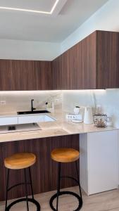 a kitchen with two stools and a counter with a sink at Casa Amarèa in Fano