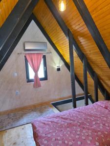 a attic room with a bed and a window at Villa Sanja I Villa Aleksa in Bratunac