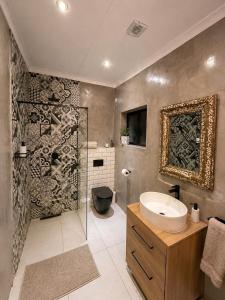 a bathroom with a sink and a shower and a toilet at Lenmed Prime Spot in Kimberley