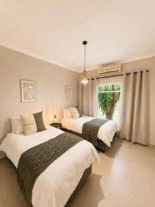 a bedroom with two beds and a window at Lenmed Prime Spot in Kimberley