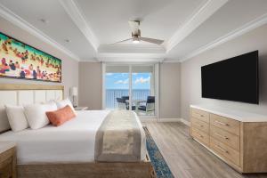 a bedroom with a large bed and a flat screen tv at Sunseeker Resort Florida Gulf Coast, Curio Collection Hilton in Punta Gorda