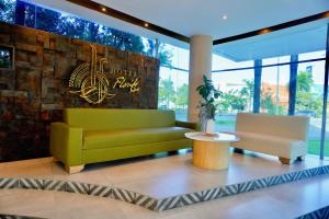 a lobby with a green couch and two chairs at Hotel Florida Sinú in Montería