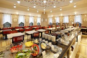 神戸市にあるホテル モンテ エルマーナ神戸 アマリーのテーブルと椅子、食べ物が備わる広い客室です。