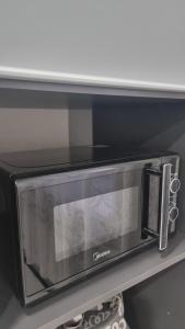a black microwave oven sitting on a shelf at Luxury in Kokshetau