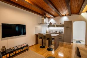 a kitchen with a table and a tv on the wall at UrbanApartment5 in Čakovec