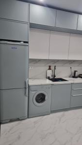 a kitchen with a washing machine and a sink at Luxury in Kokshetau