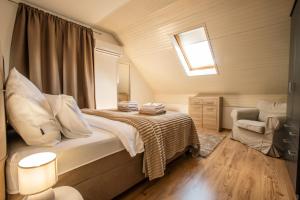 a bedroom with a bed and a window and a chair at UrbanApartment5 in Čakovec