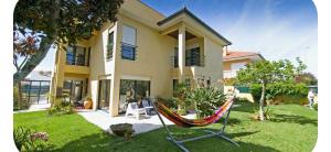 a hammock in a yard in front of a house at Casa SAL in Esposende