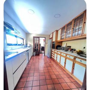 a kitchen with a red tiled floor and cabinets at Casa SAL in Esposende