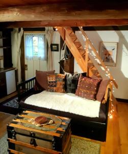 a room with a couch and a bed with a trunk at Le Temps Perdu in Westport