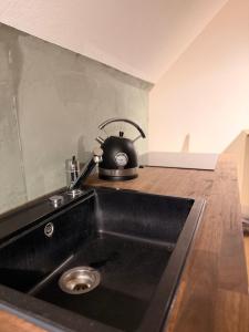 a black tea kettle sitting on top of a kitchen sink at LevelUp Comfort in Koblenz