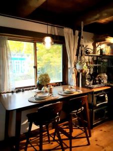 a kitchen with a table with chairs and a window at Le Temps Perdu in Westport