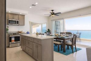 a kitchen with a table and a dining room with a view at Panoramic Oceanfront Resort Style Condo in Rosarito
