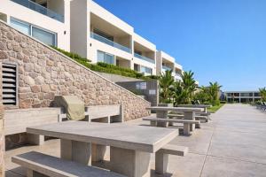 a row of benches in front of a building at Panoramic Oceanfront Resort Style Condo in Rosarito