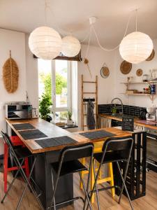 a kitchen with a large wooden table with chairs at Côte d'Opale - Maison Cocooning Classé 3 Étoiles in Marquise
