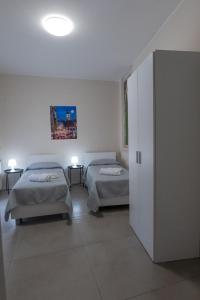 a bedroom with two beds and a closet with two lamps at Umberto I in Nicosia +2 photos
