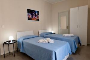 two beds in a room with blue sheets at Umberto I in Nicosia