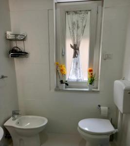 a bathroom with a toilet and a window with flowers at Umberto I in Nicosia