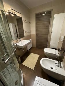 a bathroom with two sinks and a toilet and a mirror at Sončna vila Bovec, Studio A&B in Bovec